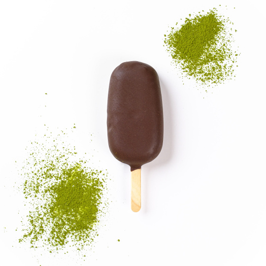 Мороженое со вкусом зеленого чая матча на палочке в черном шоколаде